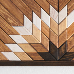 farklı ağaç tonlarının birleşimiyle oluşturulmuş, zanaatkar dokunuşu taşıyan modern geometrik ahşap sanat eseri.